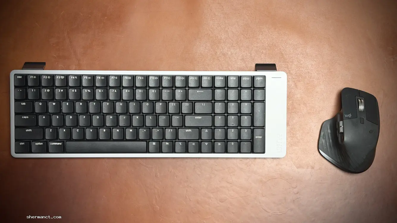 <strong>A Flawed Footprint:</strong> In a standard desk arrangement, the extended right-side bezel of the LOFREE Flow2 encroaches awkwardly onto the desk mat, competing for the exact real estate needed by the mouse.